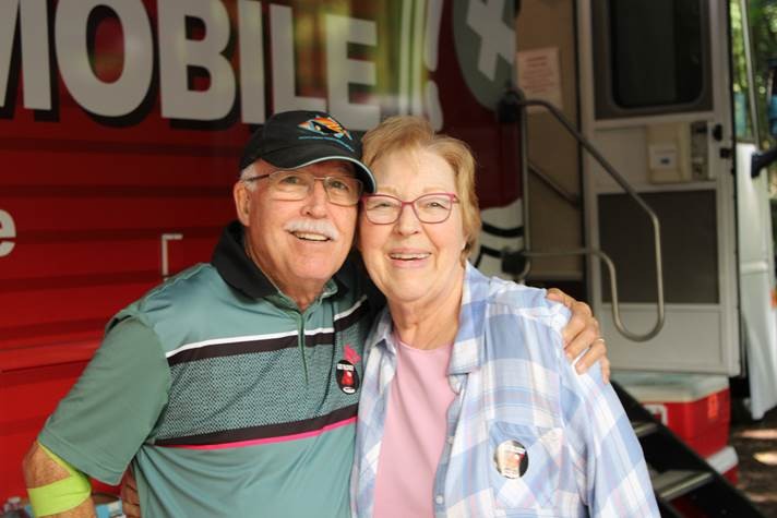Donor couple in front of the Northern California Community Blood Bank bloodmobile