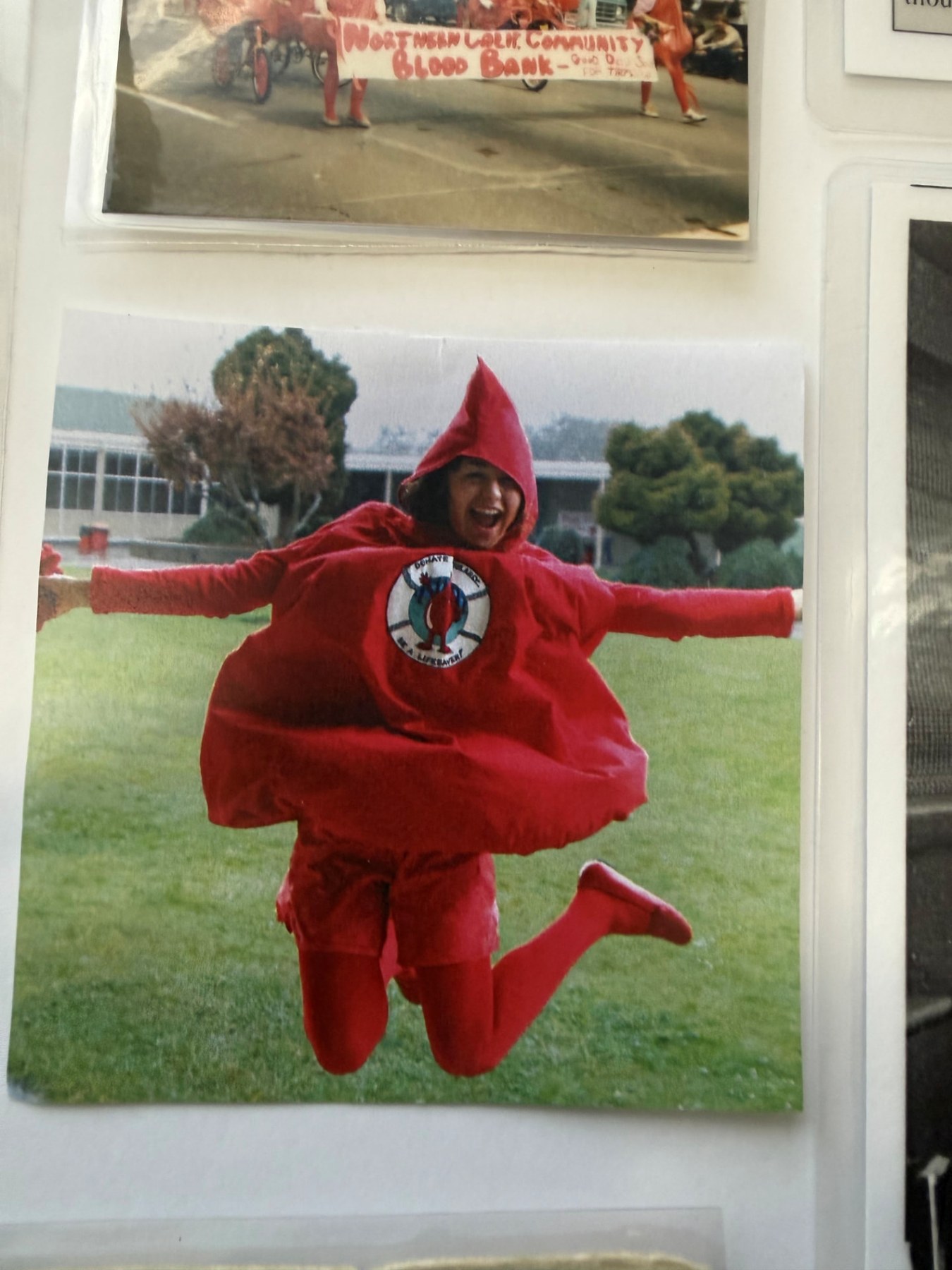 Two people wearing a historic red blood-drop mascot costume at a community event